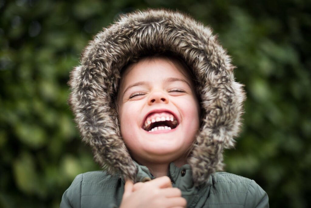 Close-up laughing child in furry hood