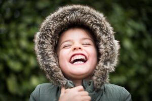 Close-up laughing child in furry hood