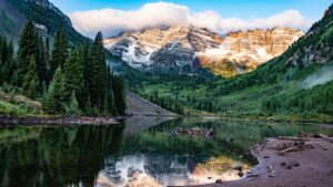 Alpine lake with snowy peaks reflection