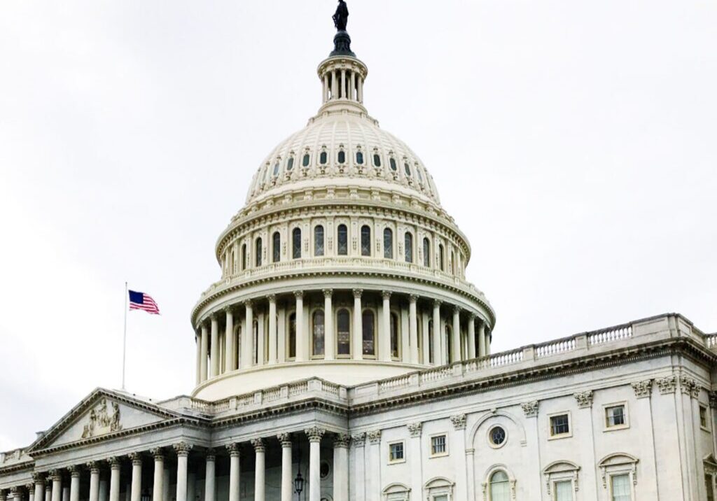 US Capitol dome with small flag
