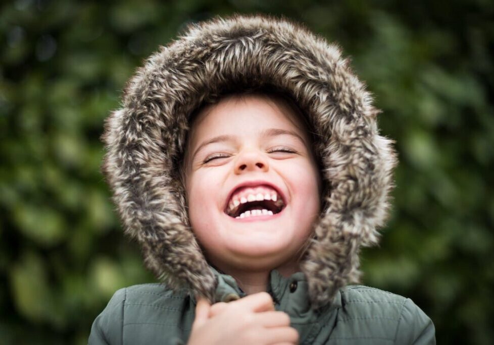 Close-up laughing child in furry hood
