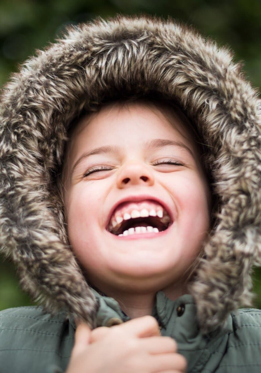 Close-up laughing child in furry hood