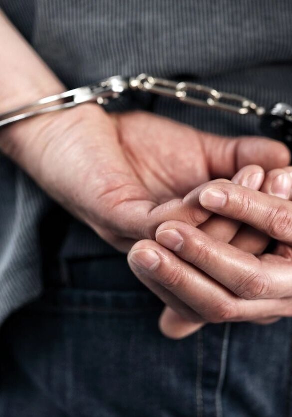 Hands cuffed behind back closeup