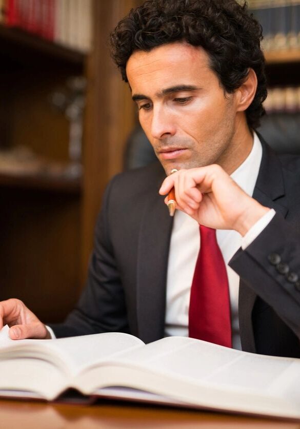 Man in suit reading large legal book