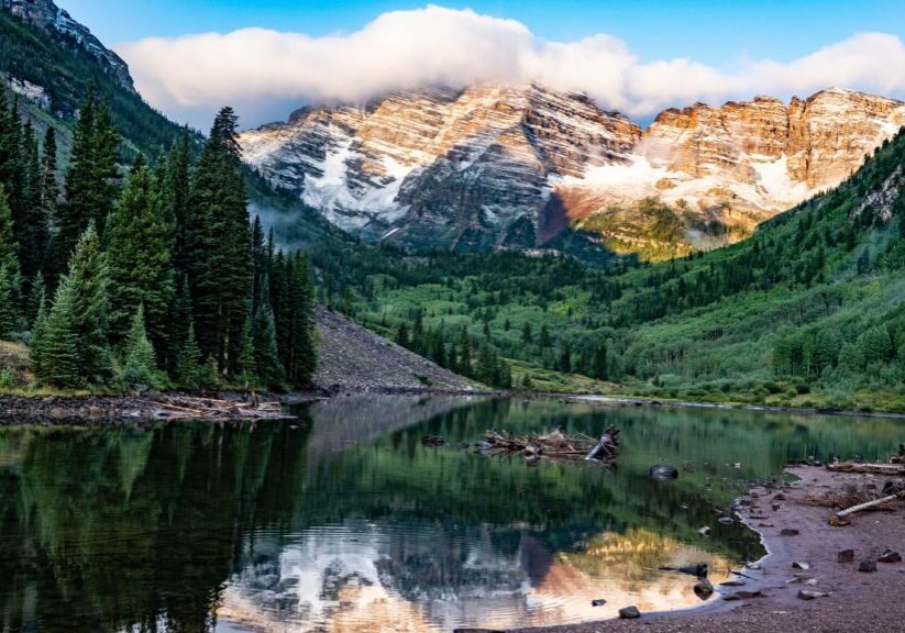 Alpine lake with snowy peaks reflection