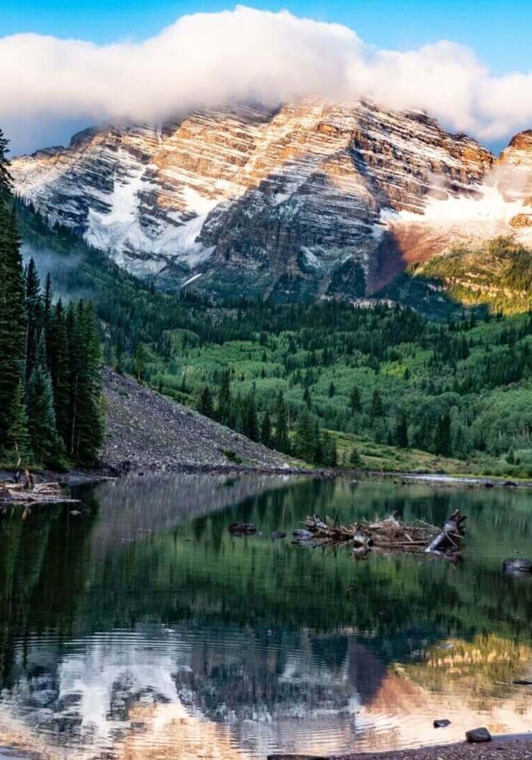 Alpine lake with snowy peaks reflection